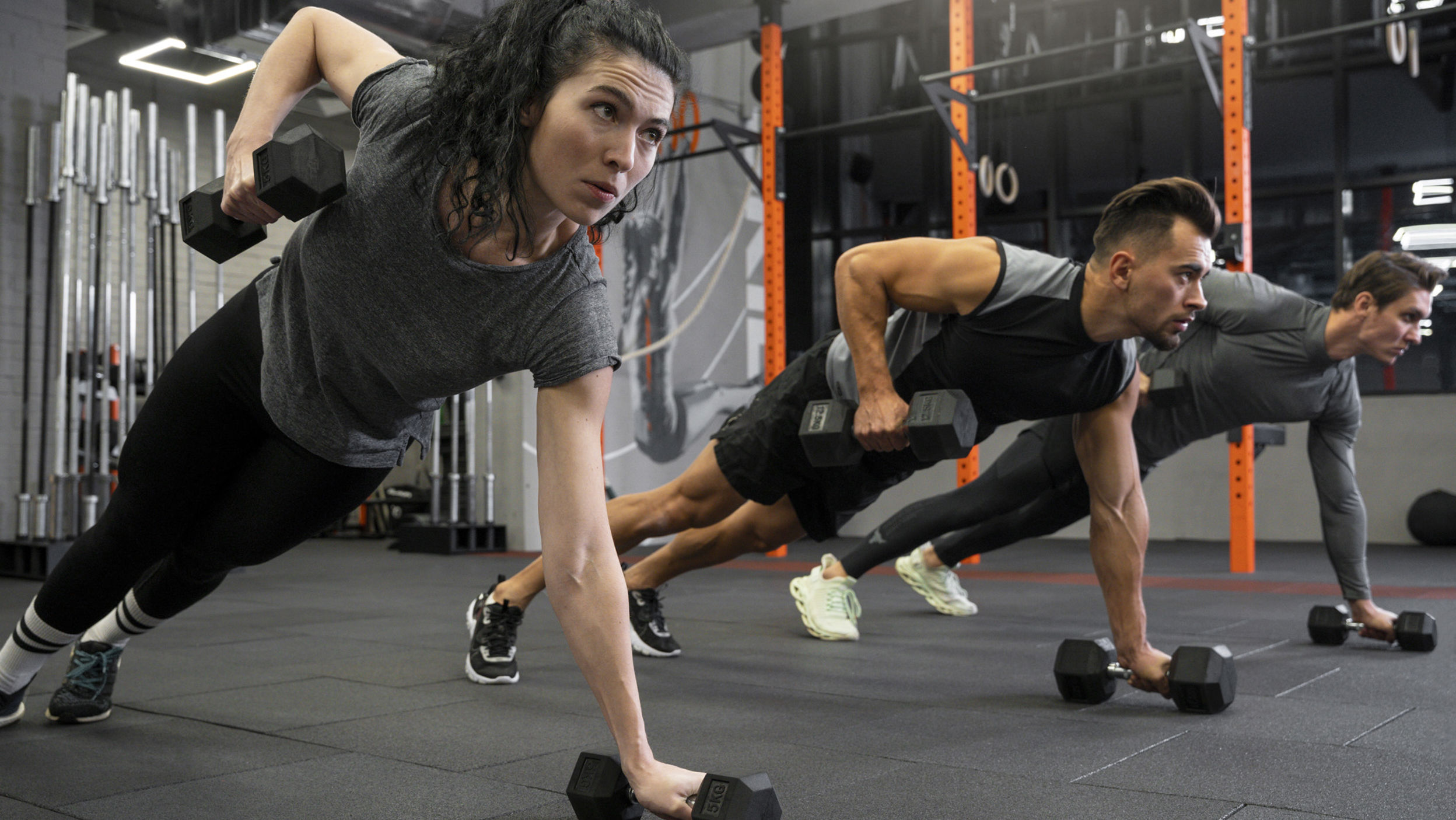People Working Out Indoors Together With Dumbbells