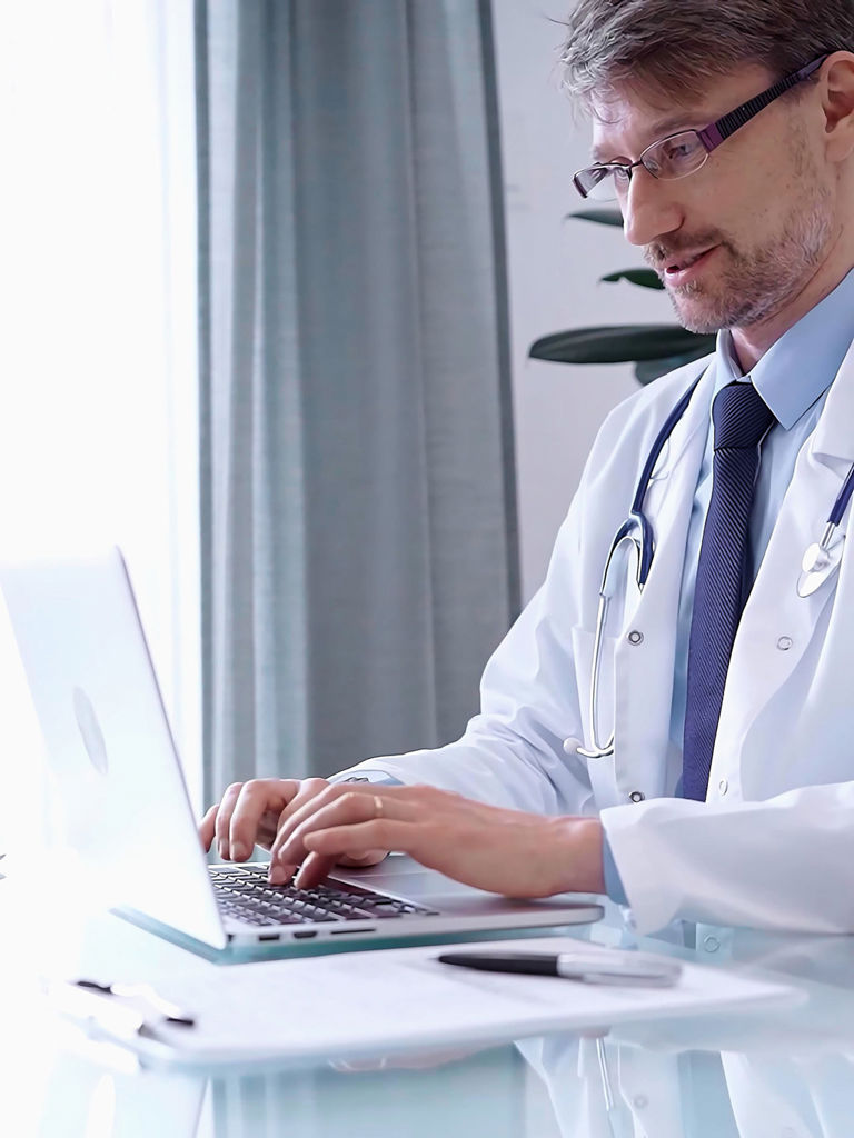 Male Physician White Coat Focused Laptop Data Modern Clinic Office While Analyzing 2