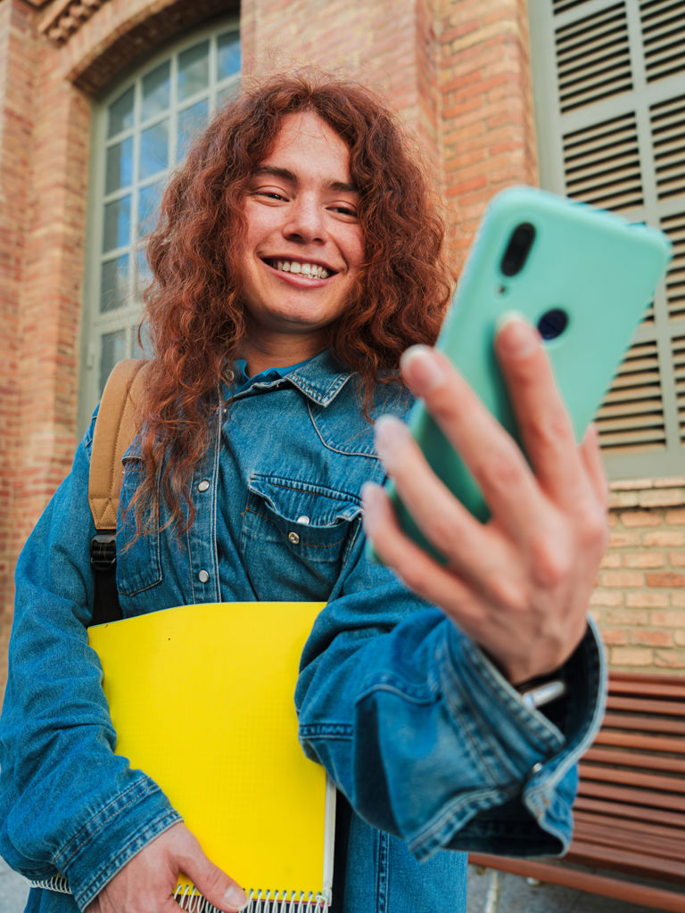 Vertical Happy Young University Student Using Her Smartphone Messaging Social Media